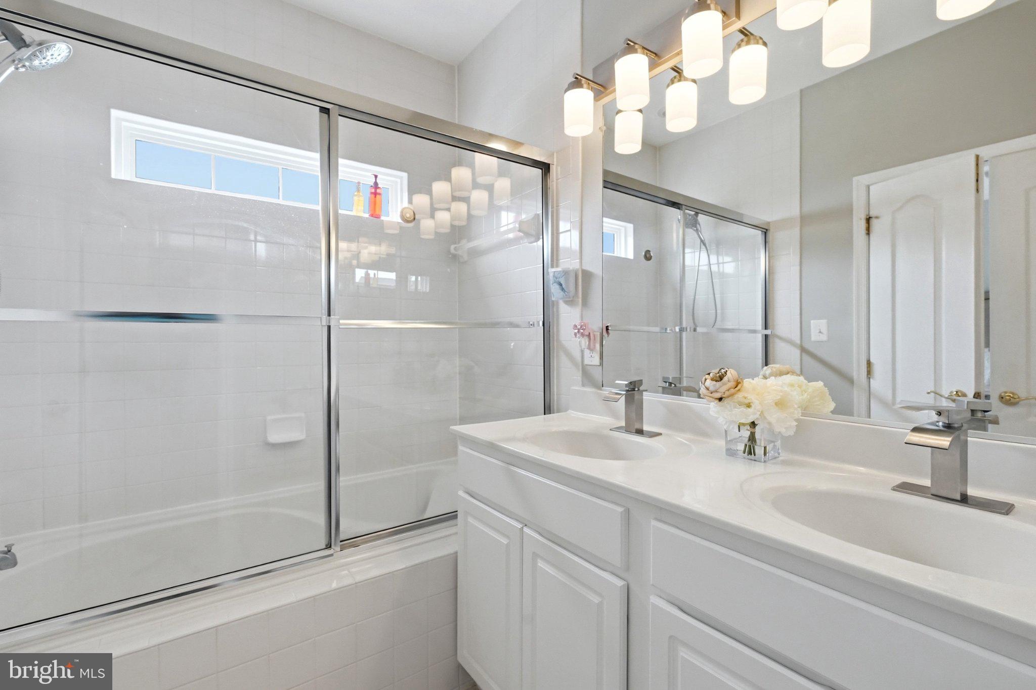 772 Raven Avenue Gaithersburg, MD 20877 - Photo 19 of 30 a bathroom with a shower sink vanity and mirror