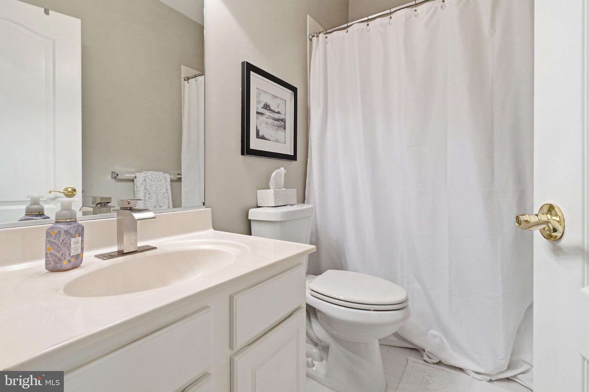 772 Raven Avenue Gaithersburg, MD 20877 - Photo 21 of 30 a bathroom with a sink a toilet and shower curtain