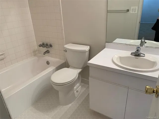 a white toilet sitting next to a bath tub and a shower