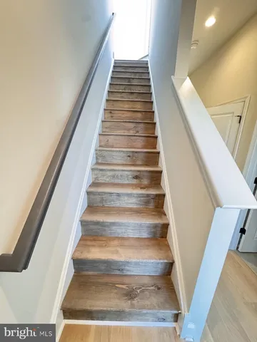 a view of a hallway with wooden floor and stairs