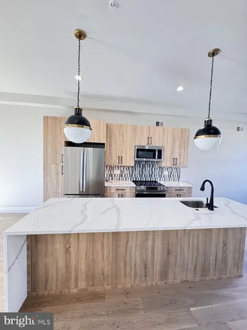 a kitchen with kitchen island a counter space a sink and appliances