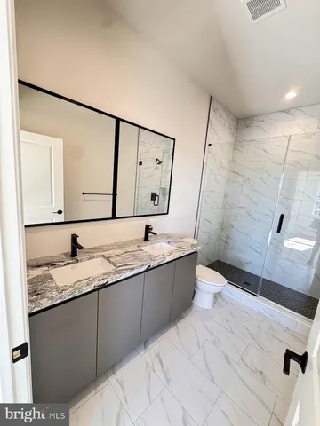 a bathroom with a sink a toilet and mirror