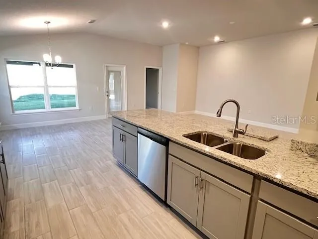 a kitchen with kitchen island granite countertop a sink and wooden floors