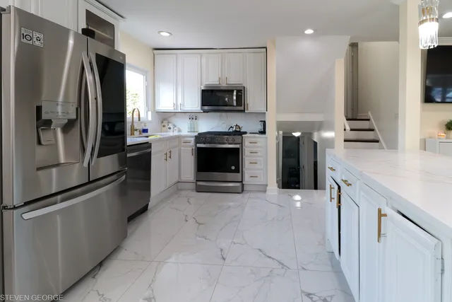 a kitchen with stainless steel appliances granite countertop a refrigerator and a stove