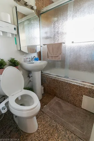 a white toilet sitting next to a bathroom sink