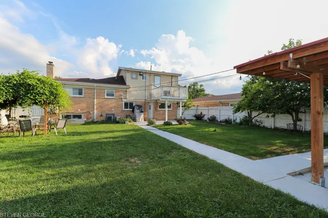 a view of a big house with a big yard and potted plants
