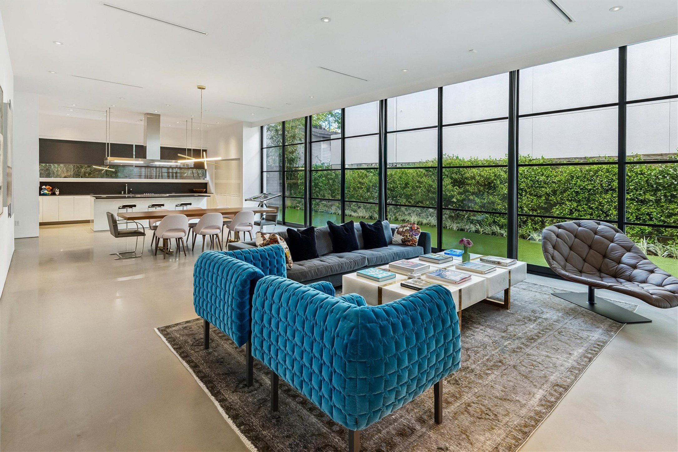 1527 Indiana Street Houston, TX 77006 - Photo 2 of 30 Living room – Walls of glass panels and sliding door open seamlessly to the outdoors. Features include linear slot diffuser air-conditioning vents in the ceiling and trim less floating Sheetrock reveals in lieu of baseboards.