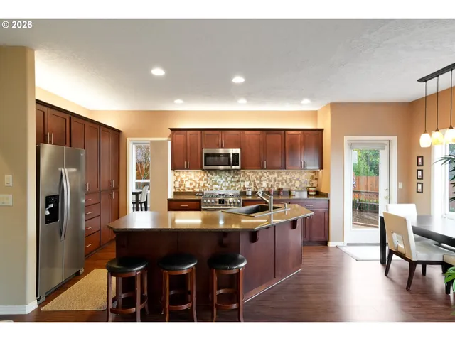 a kitchen with stainless steel appliances kitchen island granite countertop a sink and cabinets