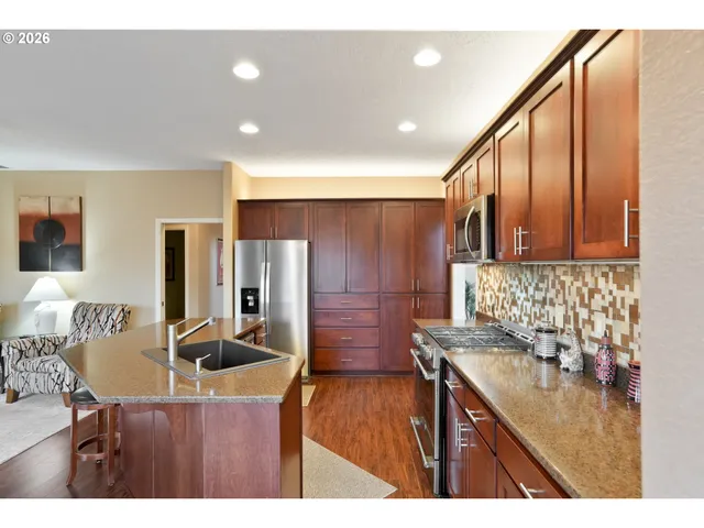 a kitchen with stainless steel appliances kitchen island granite countertop a sink and cabinets