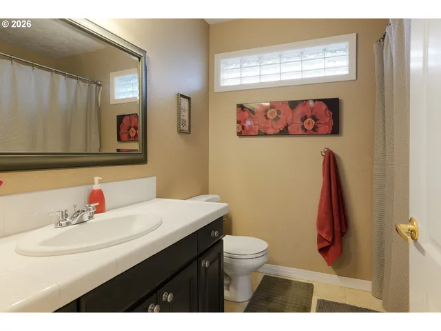 a bathroom with a sink mirror and toilet