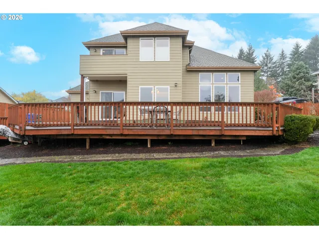a view of a house with a deck and a yard