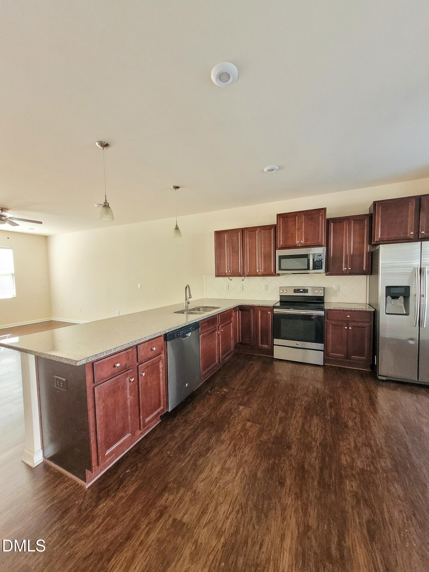 8951 Commons Townes Drive Raleigh, NC 27616 - Photo 4 of 40 a kitchen with stainless steel appliances kitchen island granite countertop a stove a sink and a microwave