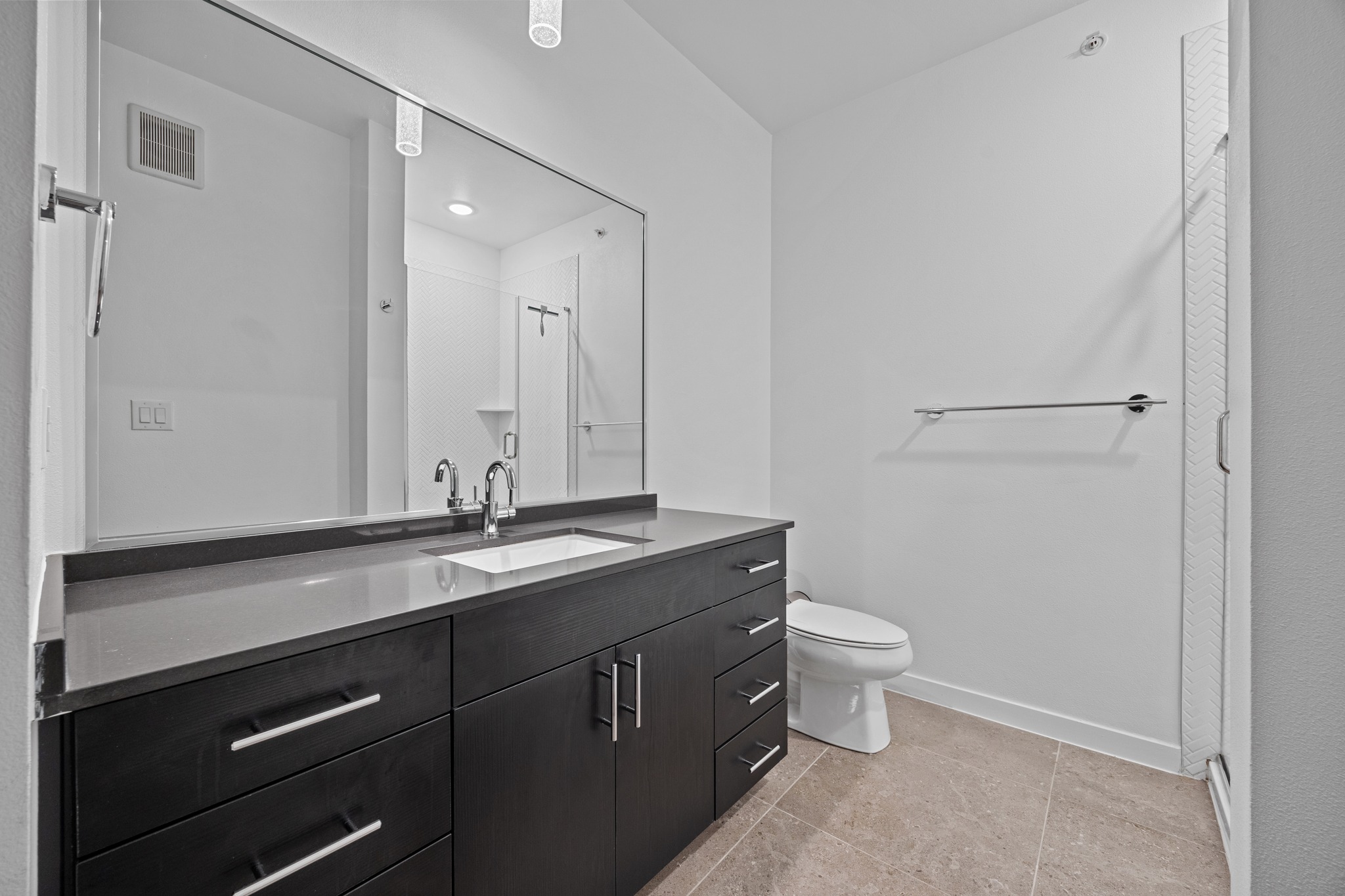 4801 Springdale Road, Unit 2301 Austin, TX 78723 - Photo 15 of 36 A well-appointed bathroom features a dark wood vanity with a pristine countertop and sleek basin.