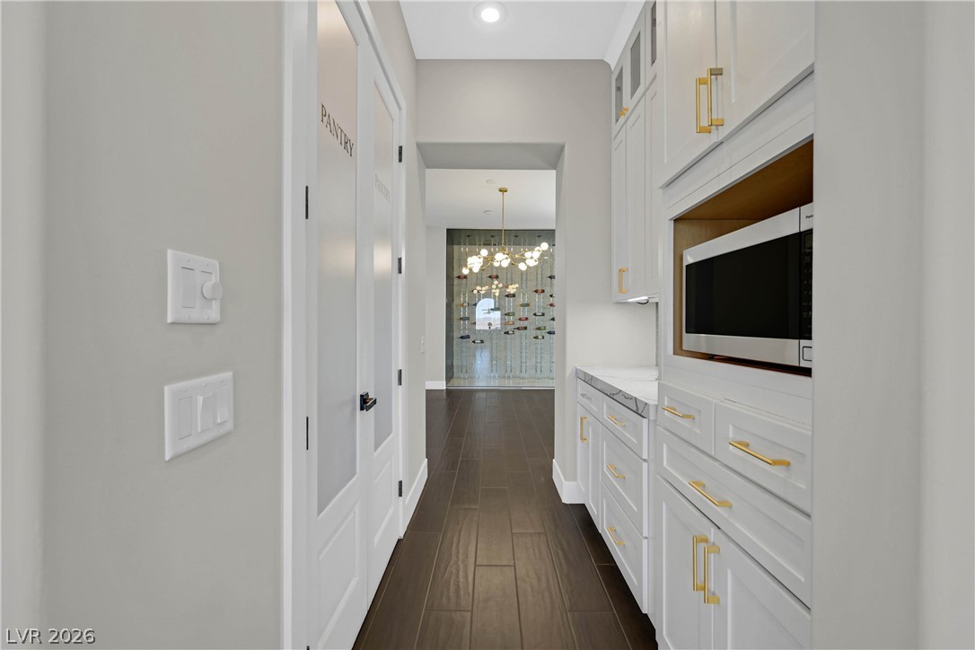 6 Rue Du Ville Henderson, NV 89011 - Photo 40 of 99 This butler's pantry features ample storage, a built-in microwave, and a convenient pass-through to the wine cellar.