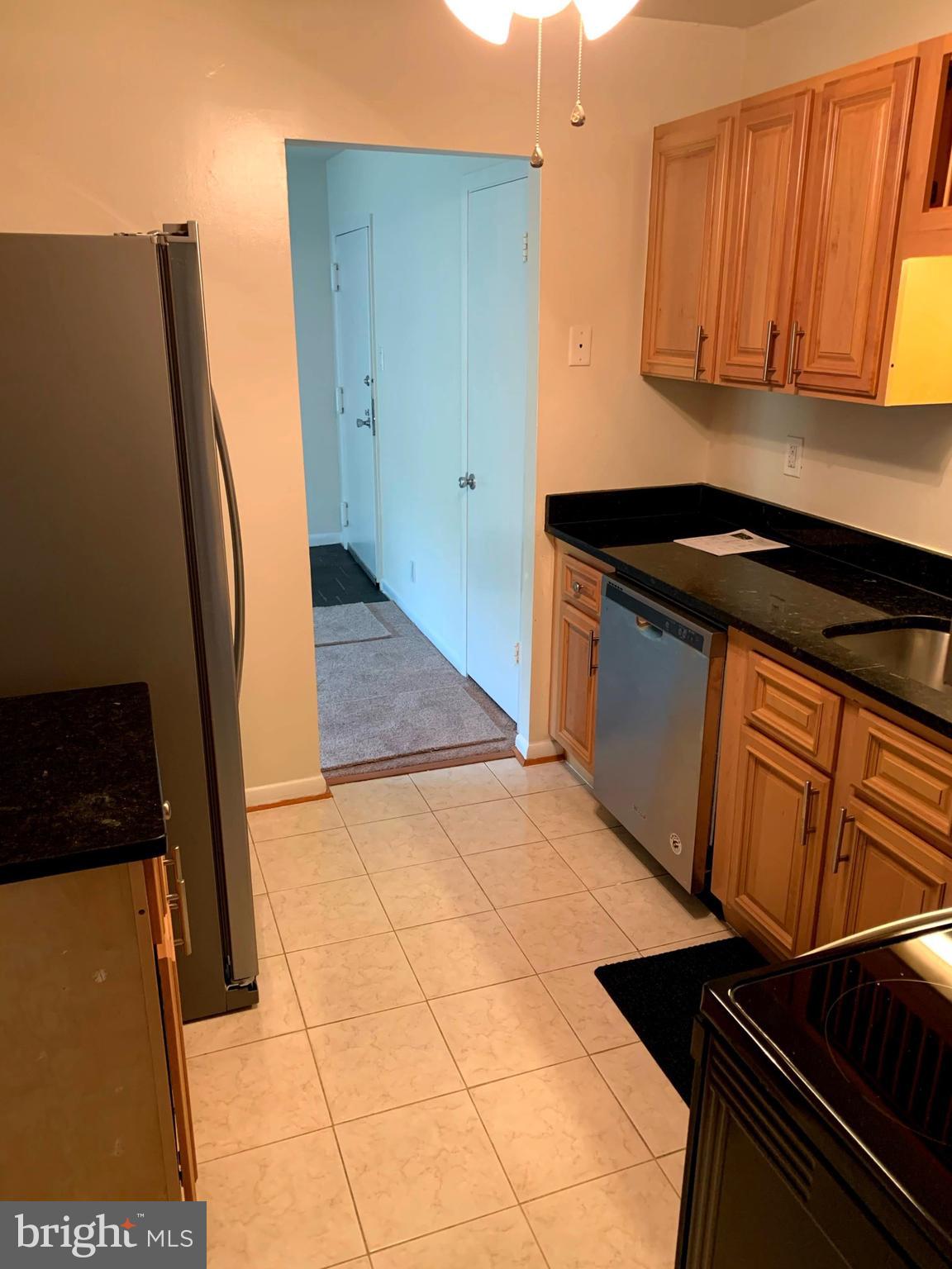 6220 Edsall Road, Unit 101 Alexandria, VA 22312 - Photo 2 of 6 a kitchen with granite countertop a refrigerator and a stove
