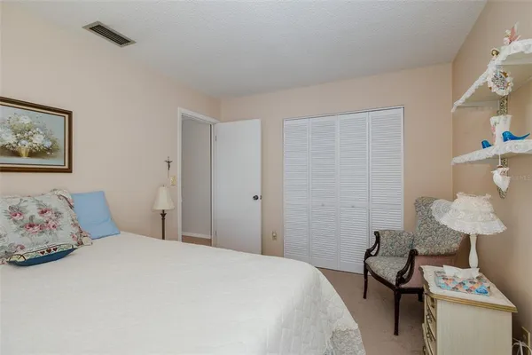 a bedroom with a bed and a lamp on the dresser