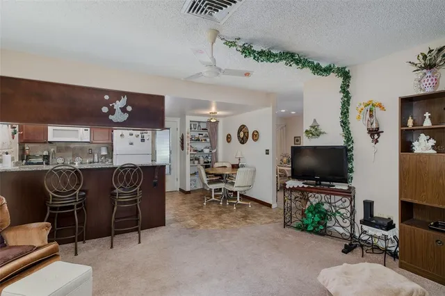 a living room with furniture a flat screen tv and gym equipment