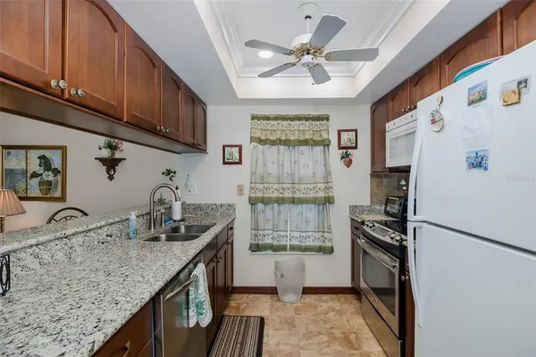 a kitchen with granite countertop a sink appliances cabinets and counter space