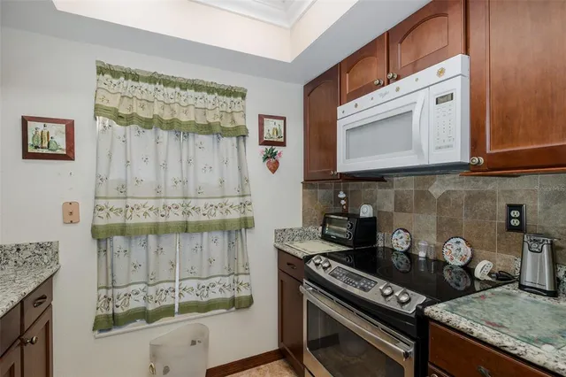 a kitchen with granite countertop a stove a sink and a microwave