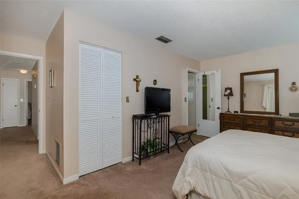 a bedroom with a bed and a flat tv screen on wall