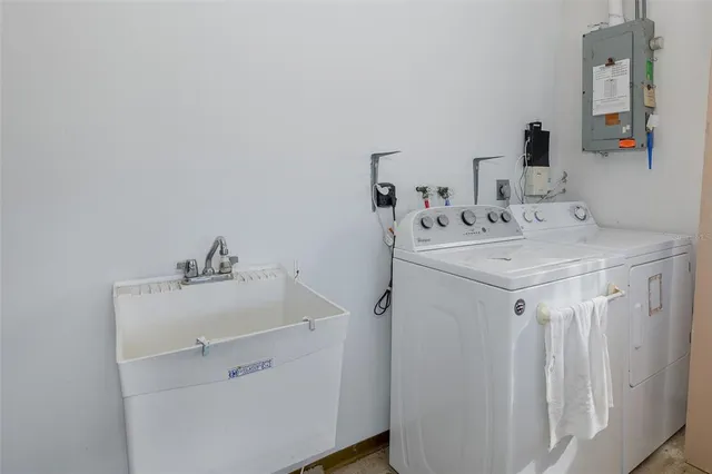 a utility room with sink dryer and washer