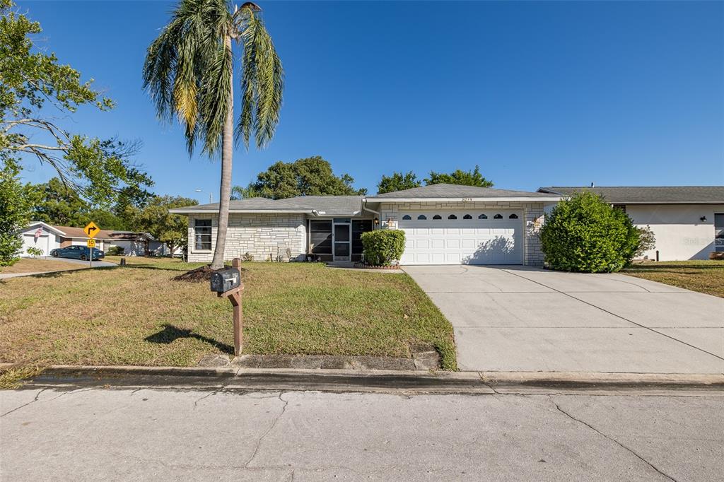 8015 San Fernando Drive Port Richey, FL 34668 - Photo 6 of 46 a front view of a house with a yard