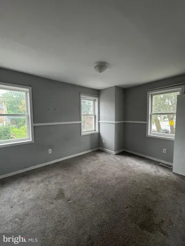 an empty room with windows and closet