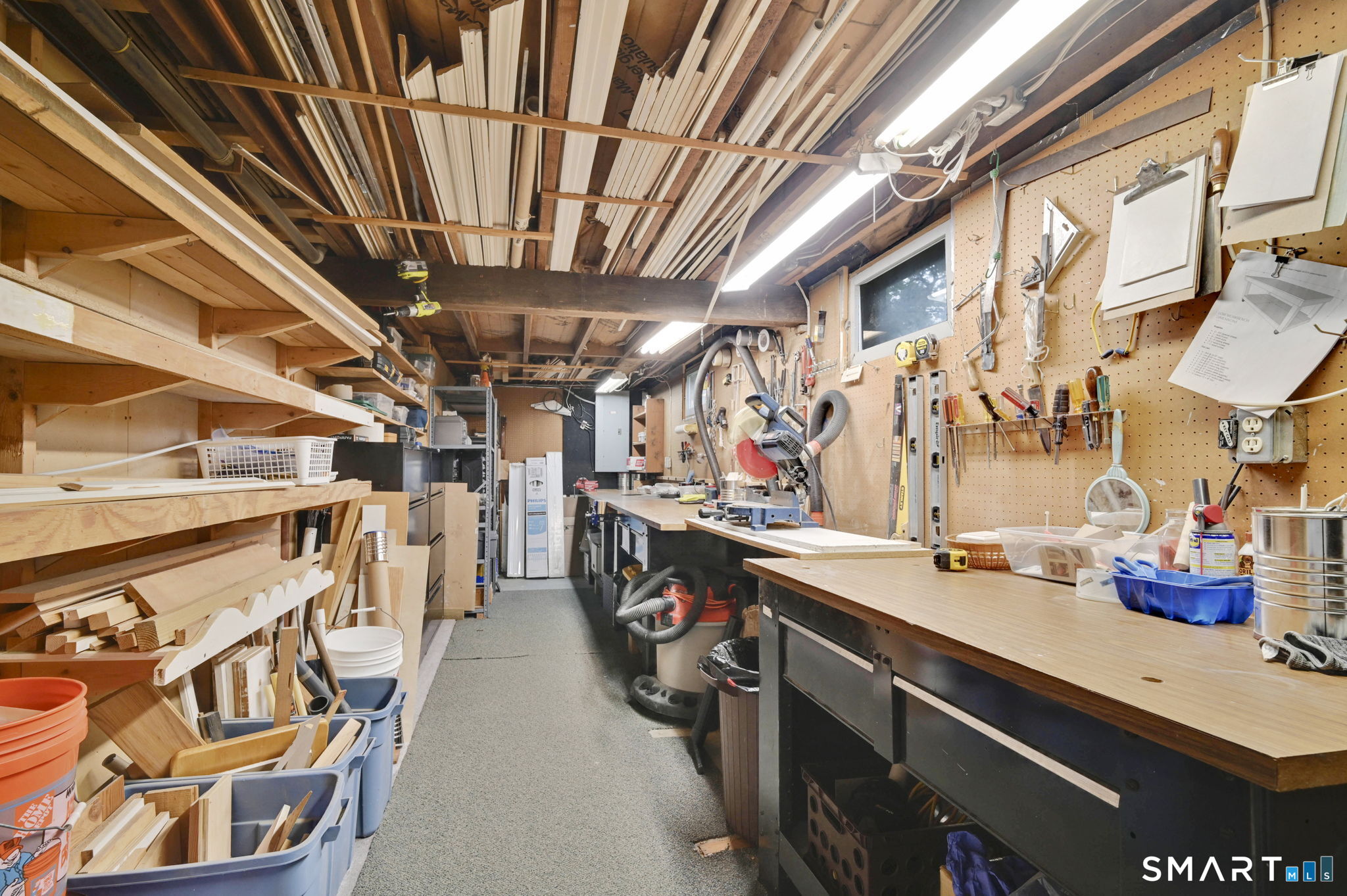35 S Road Enfield, CT 06082 - Photo 33 of 40 Workshop with shelving and workbench in basement.