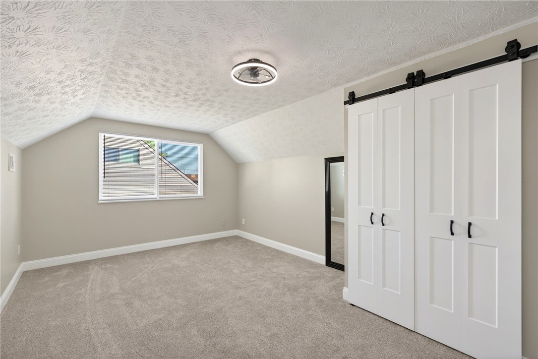 5975 Rosalie Road Dayton, OH 45424 - Photo 27 of 48 This airy bedroom features vaulted ceilings, soft carpeting, and practical barn-style closet doors.