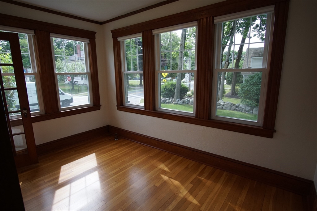 754 Massachusetts Avenue, Unit 1 Lexington, MA 02421 - Photo 5 of 17 a view of an empty room with wooden floor and a window
