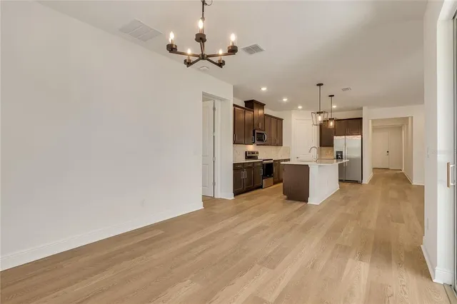 a view of a kitchen with a sink and dishwasher a refrigerator with wooden floor