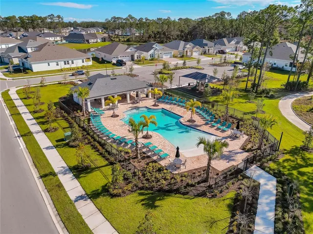an aerial view of a swimming pool with outdoor seating