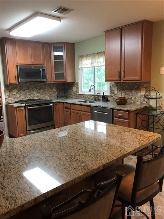 564 B Ardmore Road Monroe Township, NJ 08831 - Photo 6 of 26 a kitchen with kitchen island granite countertop wooden cabinets dining table and chairs