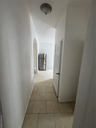 a view of hallway with a window and a refrigerator