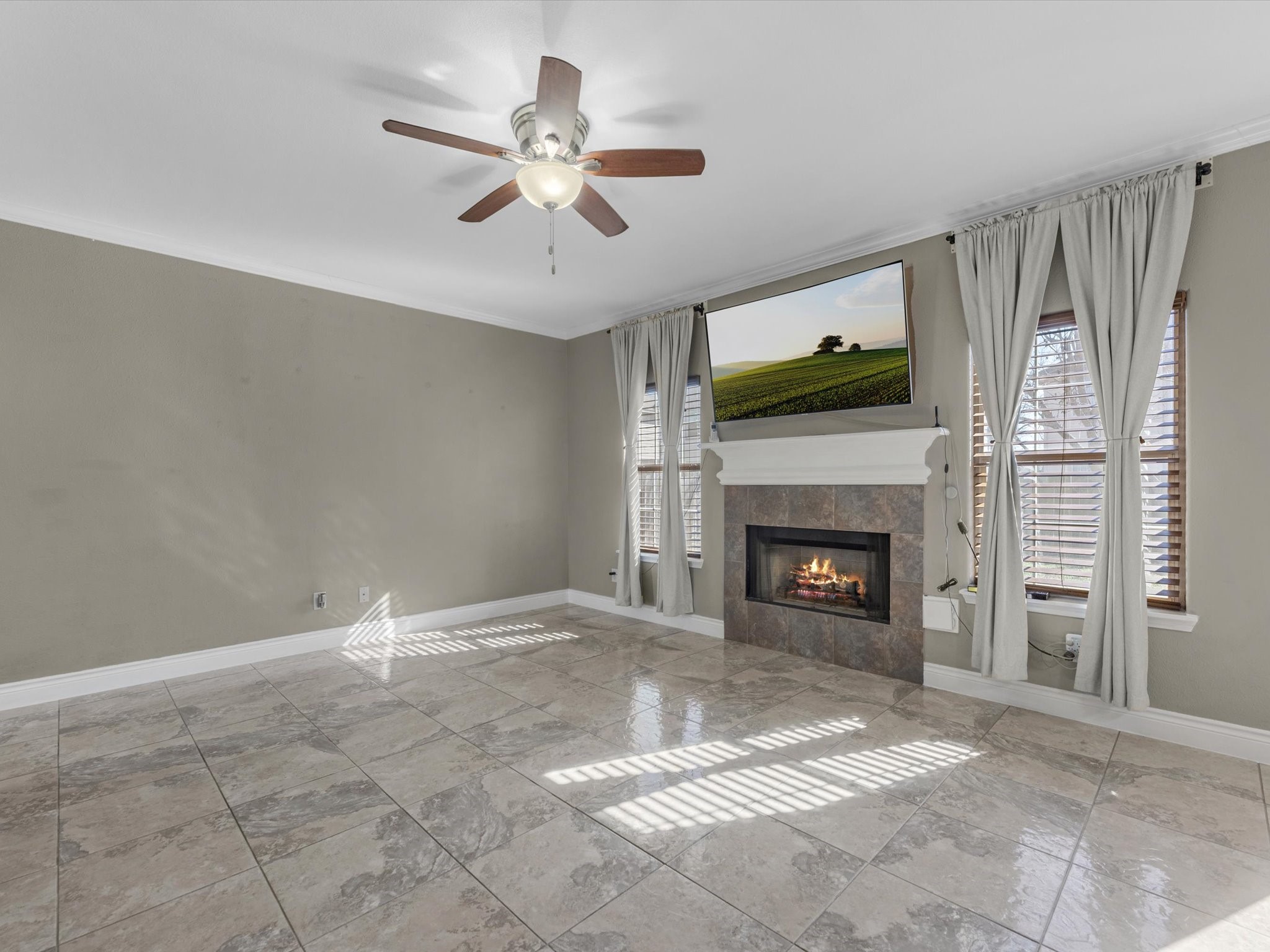 8906 Intervale Street Houston, TX 77075 - Photo 17 of 21 a view of a livingroom with a fireplace a ceiling fan and windows