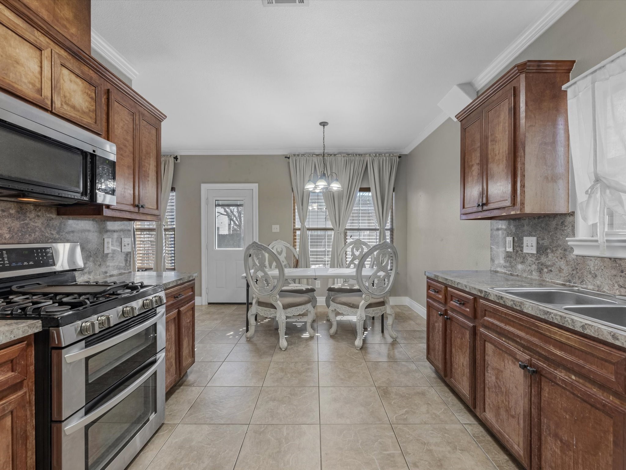8906 Intervale Street Houston, TX 77075 - Photo 5 of 21 a kitchen with stainless steel appliances granite countertop a stove top oven a sink a dining table and chairs