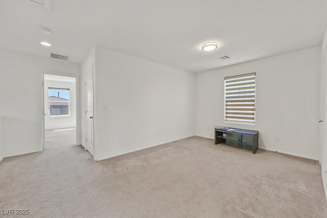 Spare room with light carpet, a smoke detector, and baseboards
