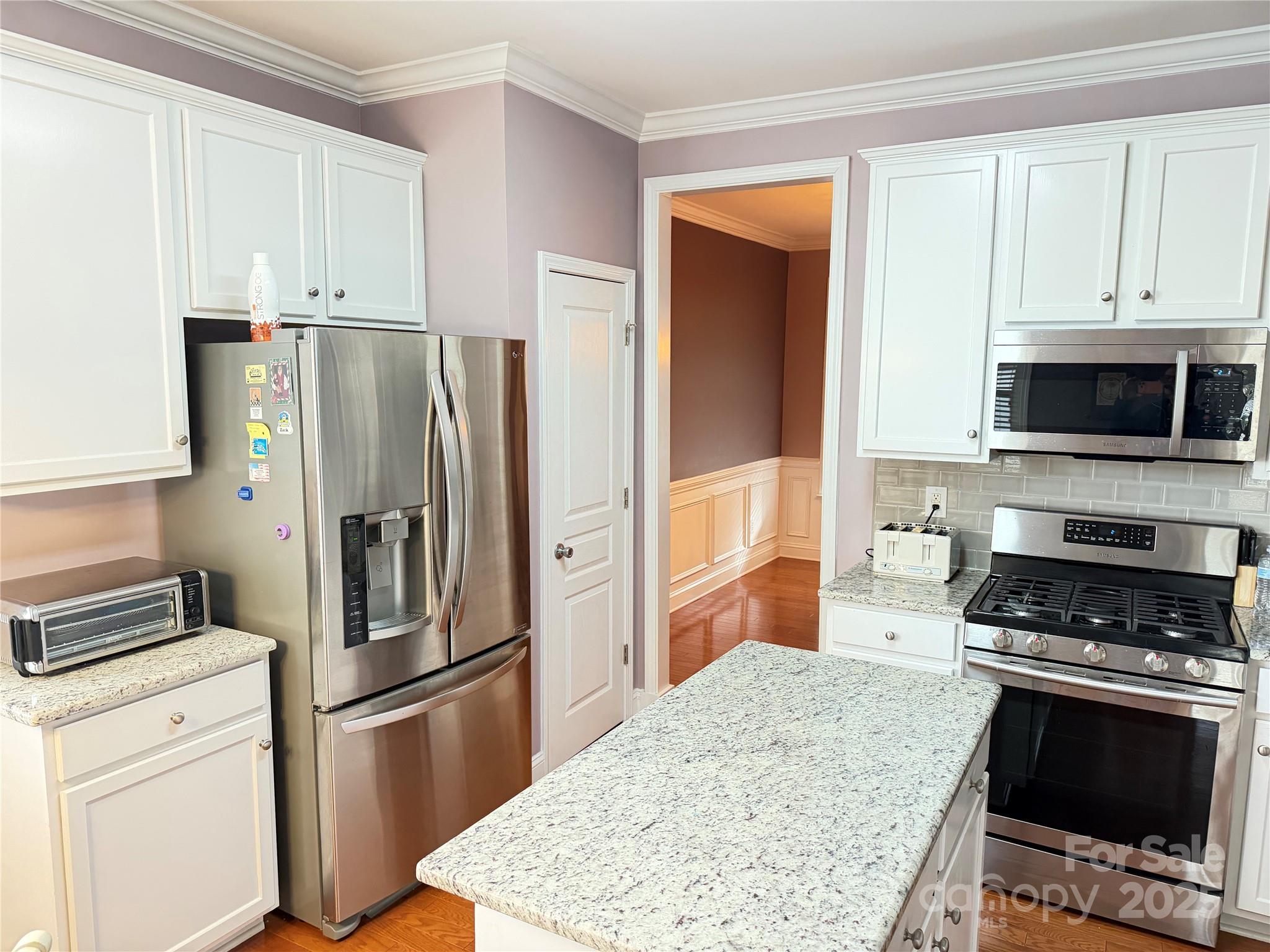 10219 Caldwell Depot Road Cornelius, NC 28031 - Photo 13 of 42 a kitchen with granite countertop a refrigerator stove and microwave