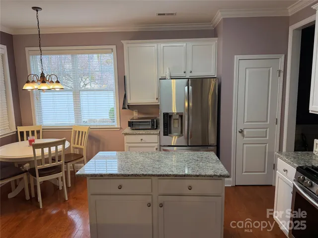 a kitchen with a table chairs sink and cabinets