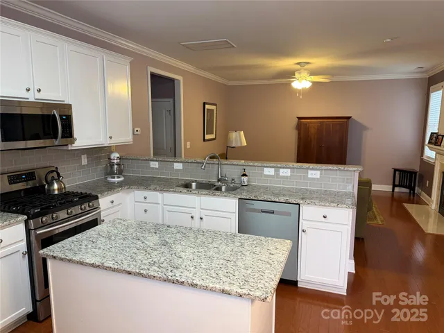 a kitchen with granite countertop a refrigerator stove and sink