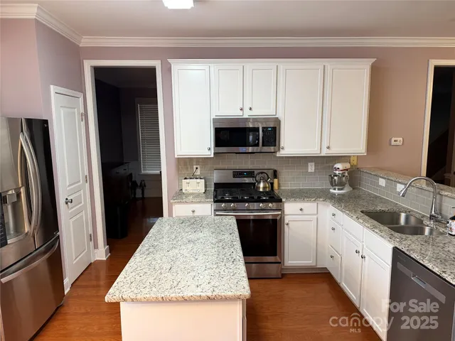 a bathroom with a granite countertop double vanity sink a mirror and vanity