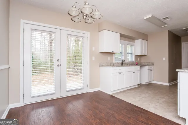 a kitchen with a wooden floor window and cabinets