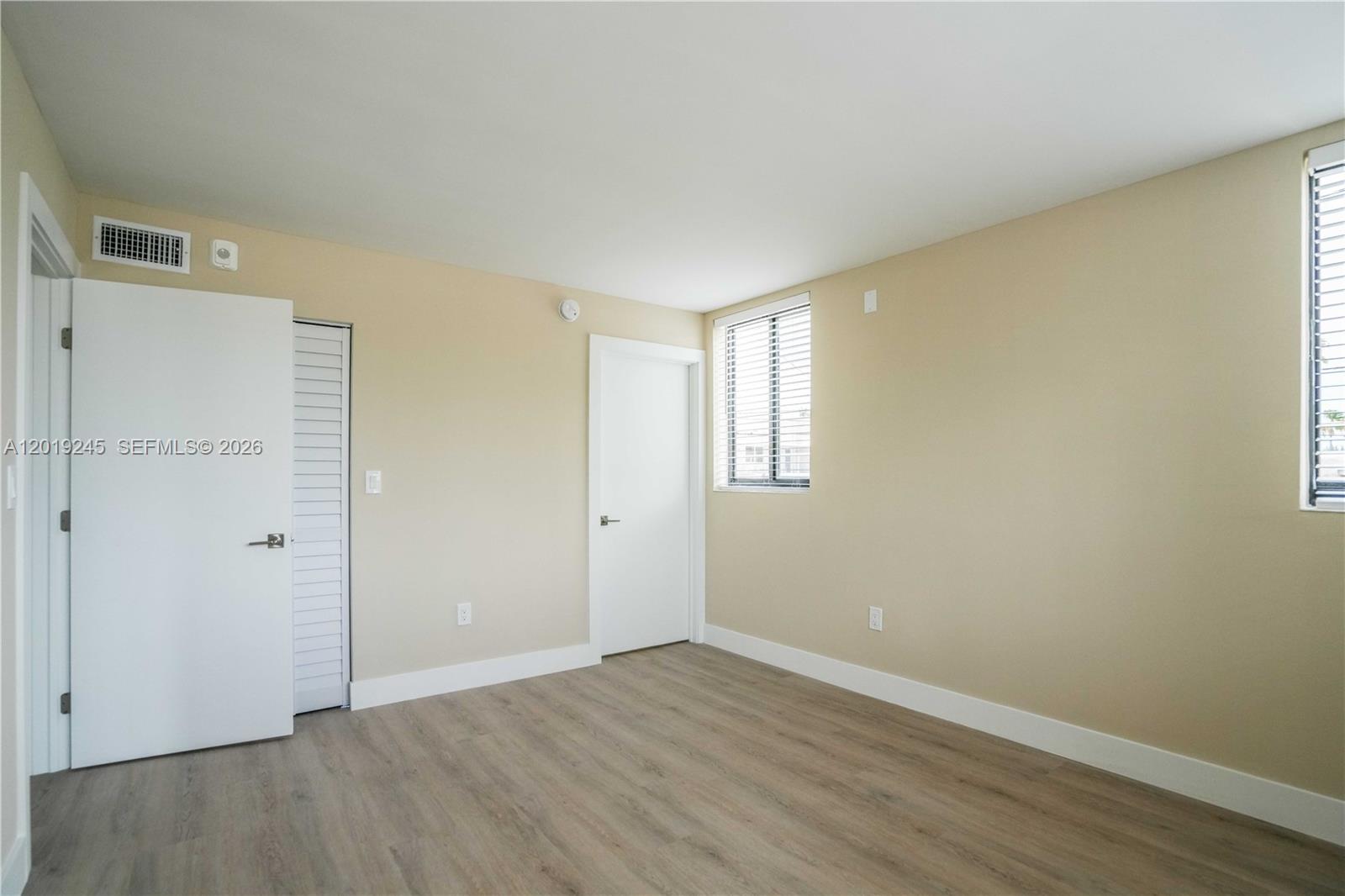 6960 Rue Vendome, Unit 201 Miami Beach, FL 33141 - Photo 9 of 27 an empty room with wooden floor and windows