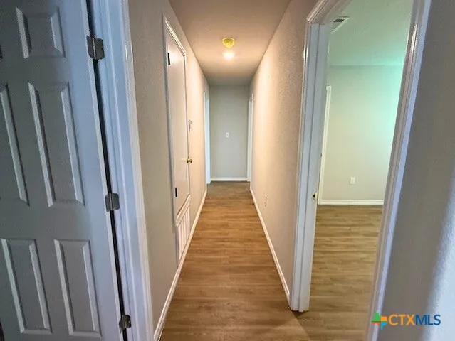 a view of an empty room with wooden floor