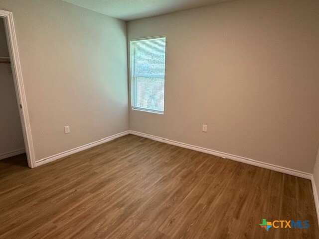 2410 Westcliff Road, Unit A Killeen, TX 76543 - Photo 21 of 22 an empty room with wooden floor and windows