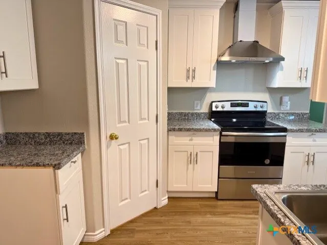 a kitchen with granite countertop a stove and a sink