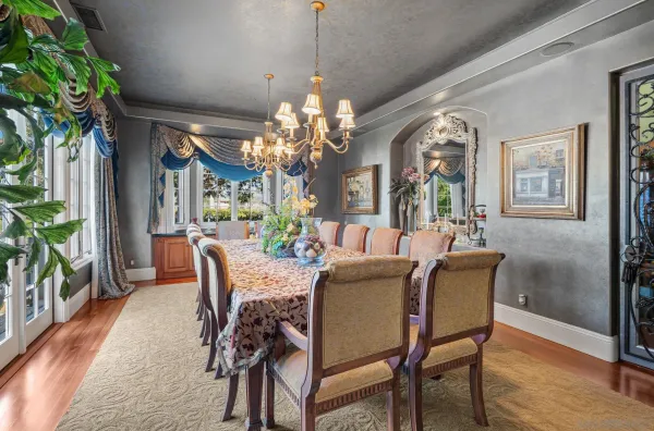 a view of a dining room with furniture a chandelier and wooden floor