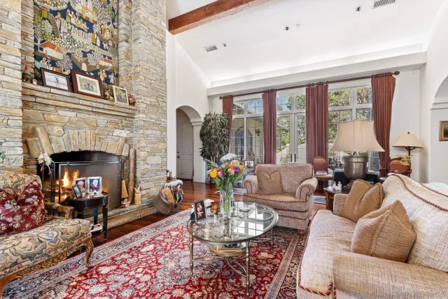 a living room with furniture fireplace and a large window