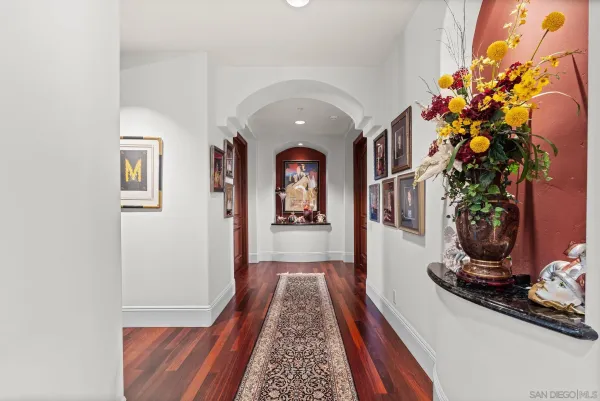 a view of a hallway with wooden floor and a potted plant