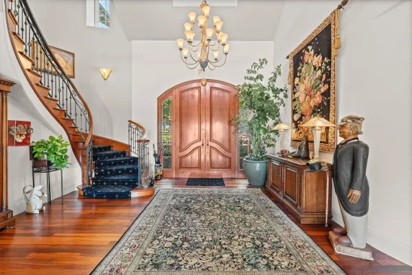 a bedroom with wooden floor stairs and a chandelier